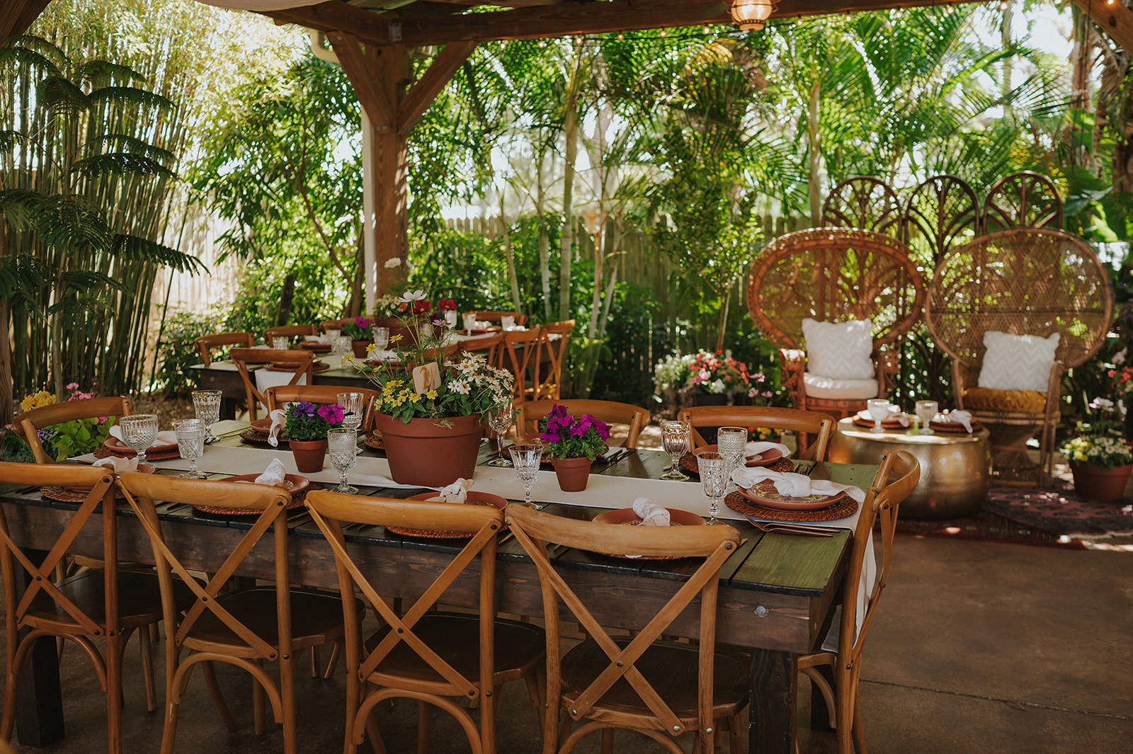 A long table set for a wedding reception under the pavilion