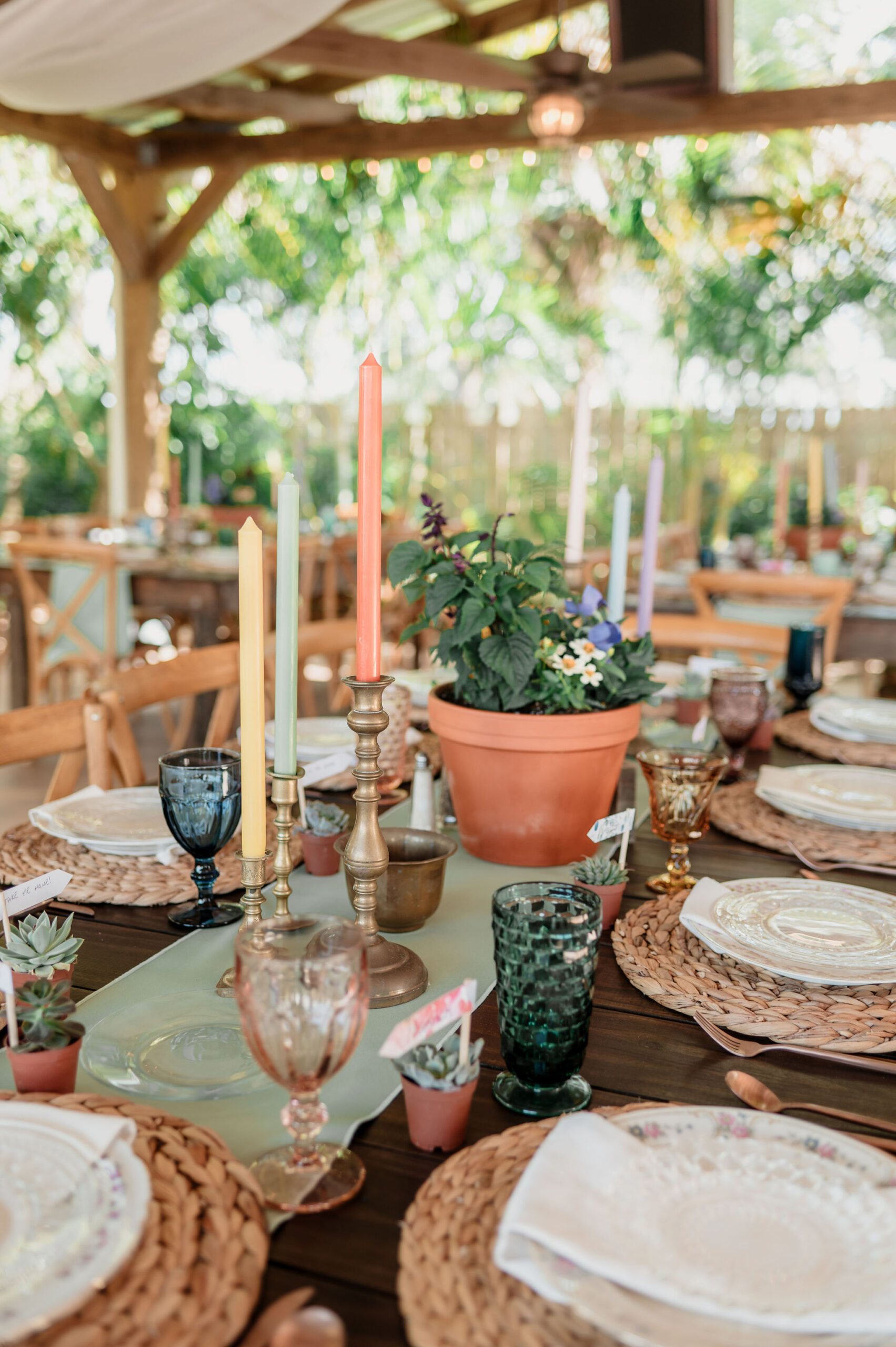 A table set with candles and a potted centerpiece